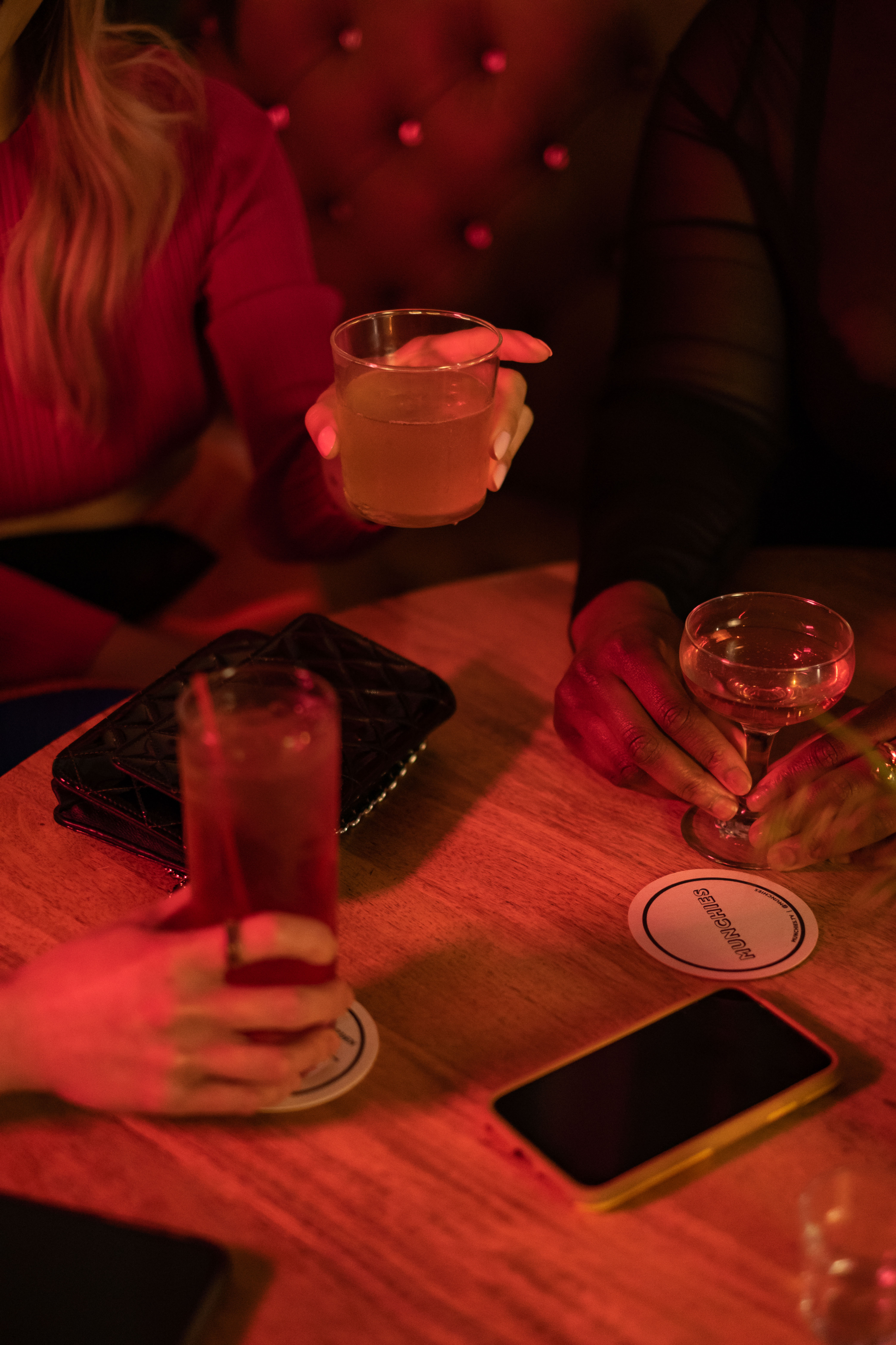 Close-up of a group of friends of varying genders having drinks at a bar